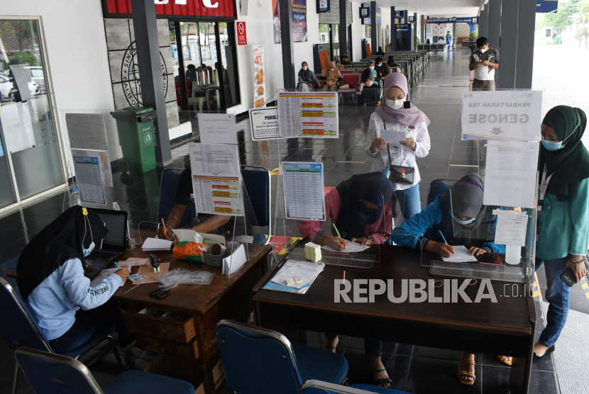 Sejumlahcalon penumpang antre untuk menjalani tes deteksi COVID-19 sebagai persyaratan penumpang Kereta Api (KA) di Stasiun KA Madiun, Jawa Timur, Sabtu (3/7/2021). PT KAI membatalkan 1.589 perjalanan KA jarak jauh maupun lokal selama penerapan Pemberlakukan Pembatasan Kegiatan Masyarakat (PPKM) Darurat mulai 3 Juli hingga 20 Juli guna pengendalian penyebaran COVID-19. 