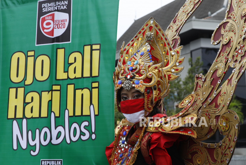 Model berbusana Solo Batik Carnival mengusung poster bertuliskan Ojo Lali Hari Ini Nyoblos di Jalan Jenderal Sudirman, Solo, Jawa Tengah, Rabu (9/12/2020). Aksi tersebut digelar untuk mengajak warga menggunakan hak pilih mereka dalam Pemilihan Kepala Daerah (Pilkada) serentak 2020. 