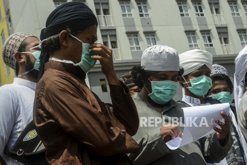 Seorang Jamaah Tabligh Masjid Jami Kebon Jeruk membaca kertas sertifikat sehat dari Rumah Sakit Darurat Covid-19 Wisma Atlet, Kemayoran, Jakarta, Selasa (14/4). (ilustrasi)