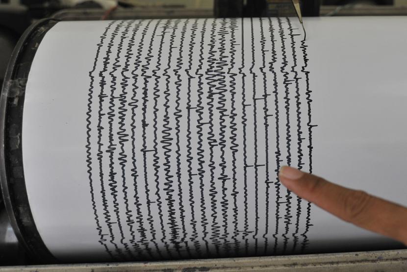 ILUSTRASI Gempa bumi. Petugas menunjuk data rekam seismograf.