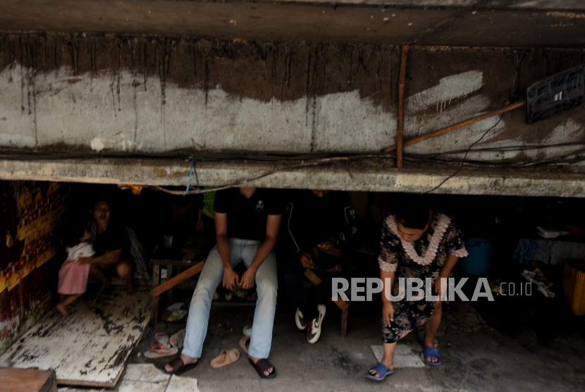 Warga beraktivitas di pemukiman kolong bawah Jalan Tol Dalam Kota, Jelambar Baru, Jakarta Barat, Selasa (20/6/2023).