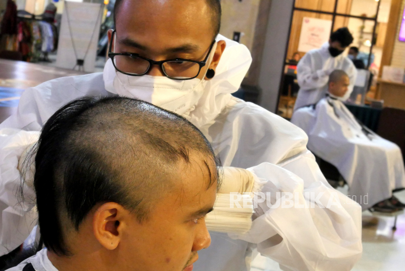 Pengunjung menjadi relawan potong rambut gundul saat aksi dalam rangka mendukung penyintas kanker. (Ilustrasi)