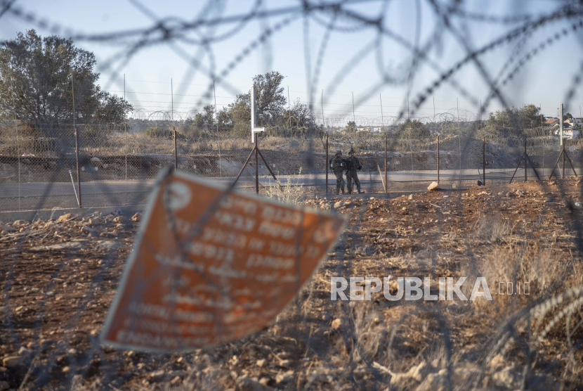 FILE - Tentara tentara Israel menjaga bagian dari penghalang pemisahan Israel, di desa Nilin Tepi Barat, barat Ramallah, Minggu, 7 November 2021. 