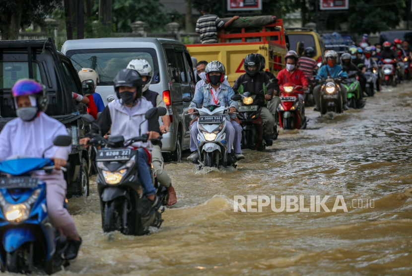 Sejumlah pengendara melintasi banjir di kawasan Tigaraksa, Kabupaten Tangerang, Banten, Rabu (20/5/2020). Genangan air tersebut di jalan tersebut terjadi akibat luapan sungai Cimanceuri