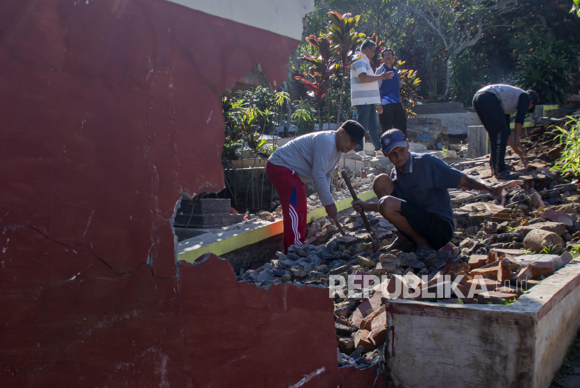 Guru bersama warga membersihkan puing pagar yang roboh pascagempa di SDN Tipar Padalarang, Padalarang, Kabupaten Bandung Barat, Jawa Barat, Senin (16/9/2024). Bangunan pagar sekolah sepanjang 30 meter itu rusak akibat gempa dengan magnitudo 5,3 di Kabupaten Sukabumi pada Ahad (15/9).