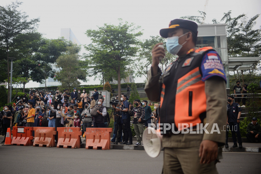 Petugas Satpol PP mengimbau warga untuk tidak berkerumun di Taman Dukuh Atas, Jakarta Pusat. Kendaraan yang parkir liar di kawasan tersebut juga akan ditertibkan.