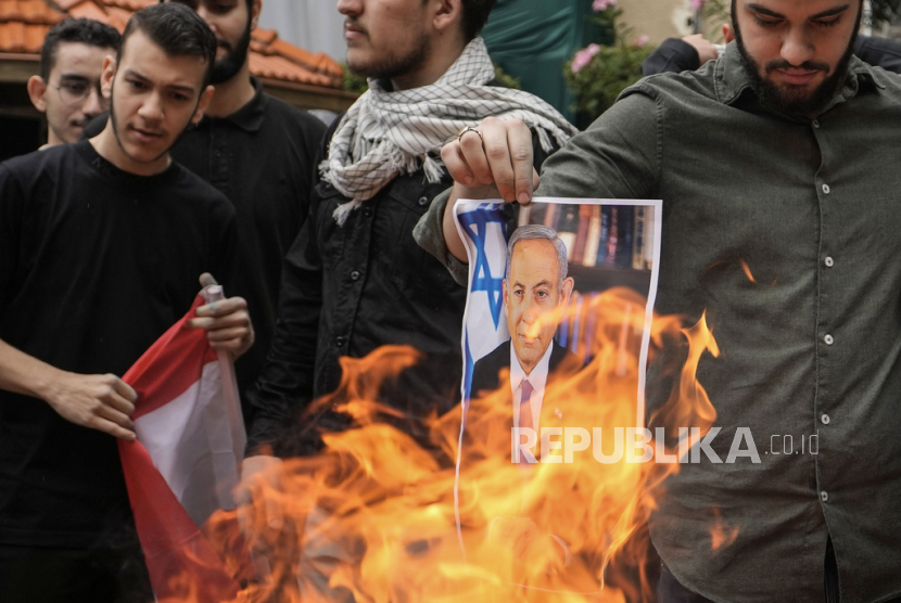 Pengunjuk rasa membakar poster Perdana Menteri Israel Benjamin Netanyahu. 