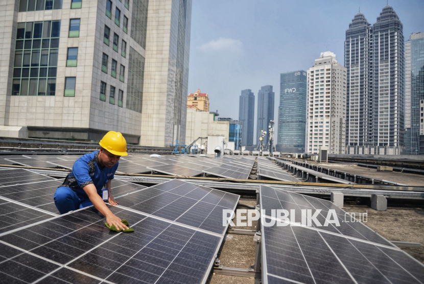 Petugas melakukan perawatan terhadap panel surya di atap gedung Kantor Pusat Bank Mandiri, Jakarta, Jumat (9/8/2024).  Kementerian Energi dan Sumber Daya Mineral (ESDM) menargetkan investasi subsektor Energi Baru Terbarukan dan Konservasi Energi (EBTKE) mencapai US$ 1,23 miliar pada tahun 2024. Kementerian ESDM menyampaikan realisasi investasi di sektor EBTKE sepanjang semester I 2024 telah mencapai US$565 juta atau setara 45,86% dari target. Sejumlah jenis EBT seperti energi surya, panas bumi, air, hingga bioenergi termasuk biogas dan biomassa menjadi penopang raihan investasi selama semester pertama tahun ini