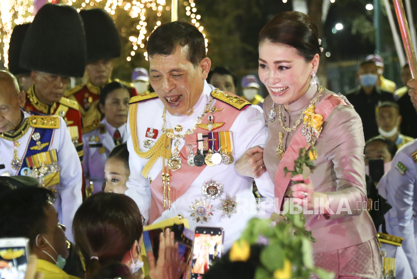  Raja Thailand Maha Vajiralongkorn Bodindradebayavarangkun (tengah) dan Ratu Thailand Suthida (kanan) menyambut para pendukung di luar Istana Agung.