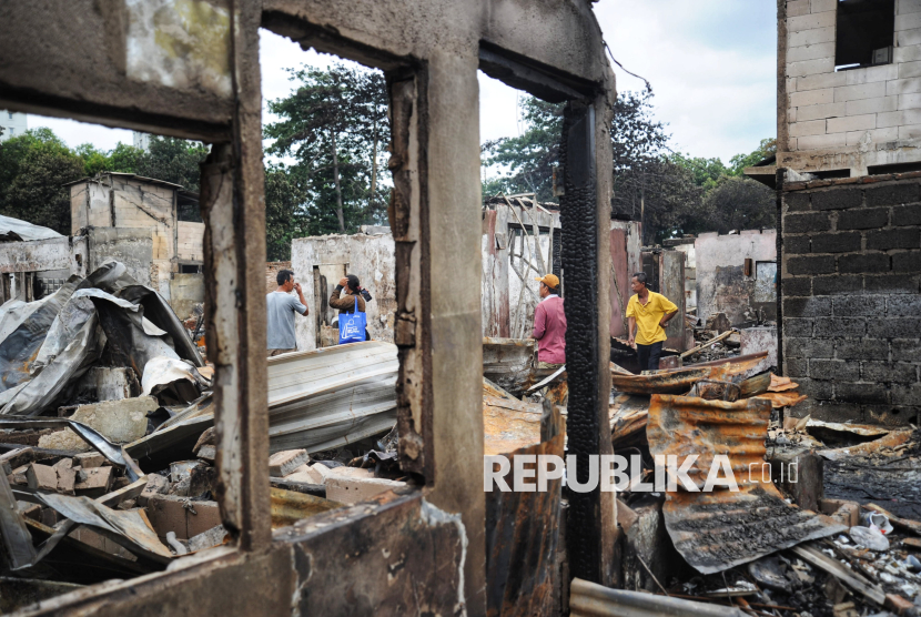 Sejumlah warga melihat rumahnya yang terbakar di lokasi kebakaran permukiman padat penduduk di Jalan Kemayoran Gempol, Kebon Kosong, Kemayoran, Jakarta, Selasa (21/1/2025). Kebakaran besar yang terjadi pada dini hari tersebut menghanguskan 543 rumah yang berdampak  terhadap 1.797 jiwa atau 607 kepala keluarga (KK). Sebanyak 34 unit mobil pemadam dengan 170 personel dikerahkan untuk menangani kebakaran tersebut. Upaya pemadaman dimulai sekitar pukul 01.22 WIB dan proses pendinginan dimulai pada pukul 06.00 WIB.