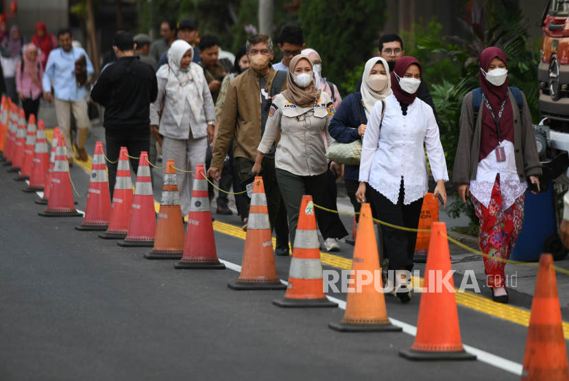 Pegawai Pemprov DKI Jakarta pulang kerja di depan Balai Kota, Jakarta. Pemprov DKI menerapkan aturan WFH bagi separuh ASN. WFH dinilai sebagai solusi jangka pendek mencegah paparan polusi udara. 