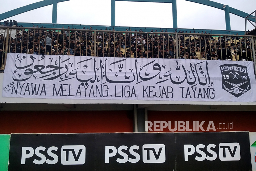 Spanduk terkait Tragedi Kanjuruhan dibentangkan suporter saat laga PSS Sleman melawan Arema pada lanjutan BRI Liga 1 di Stadion Maguwoharjo, Yogyakarta, Kamis (26/1/2023).