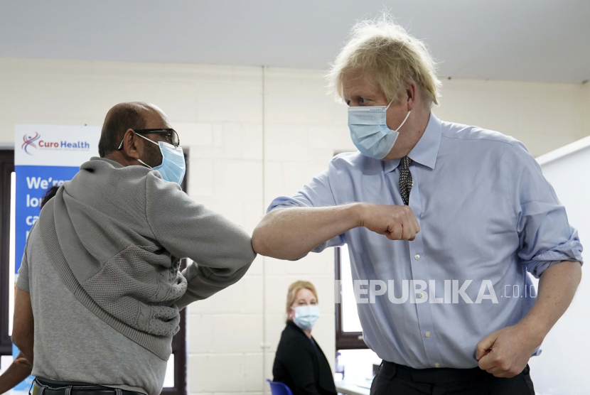 Siku Perdana Menteri Inggris Boris Johnson menabrak Ismail Patel setelah mendapatkan suntikannya saat berkunjung di pusat vaksinasi COVID-19 di Batley, West Yorkshire, Inggris, Senin, 1 Februari 2021.