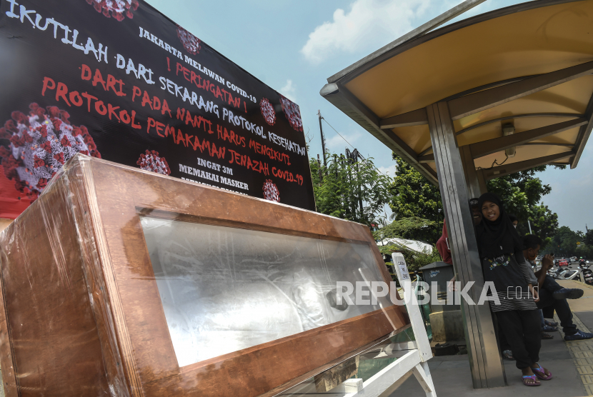 Seorang bocah berada di samping peti mati berisi replika jenazah korban COVID-19 di kawasan Tanjung Barat, Jakarta, Sabtu (5/9/2020). Pemerintah terus berupaya melakukan kampanye peringatan bahaya COVID-19 bagi masyarakat guna menekan angka positif dan kematian akibat virus tersebut. 