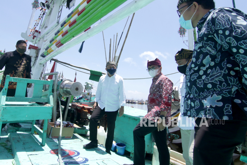 Menteri Koperasi dan UKM Teten Masduki (kedua kiri) meninjau kapal nelayan bersama Bupati Banyuwangi Abdullah Azwar Anas (ketiga kiri) di Tempat Pelelangan Ikan Muncar, Banyuwangi, Jawa Timur, Jumat (2/10/2020). Teten mengatakan saat ini tengah menyiapkan proyek percontohan koperasi sektor produksi yang mencakup sektor pangan, hasil laut, perkebunan dan peternakan. 