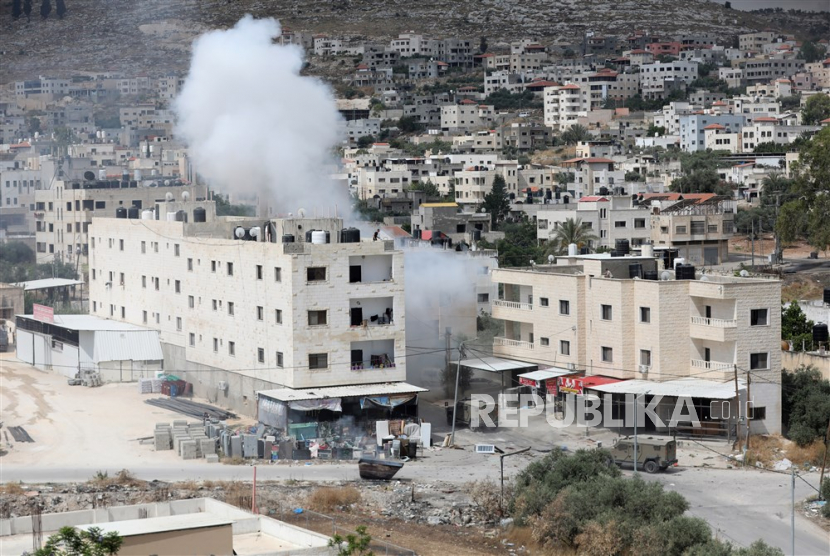 Asap mengepul dari ledakan saat serangan tentara Israel di kota Jenin, Tepi Barat, Senin (19/6/2023).