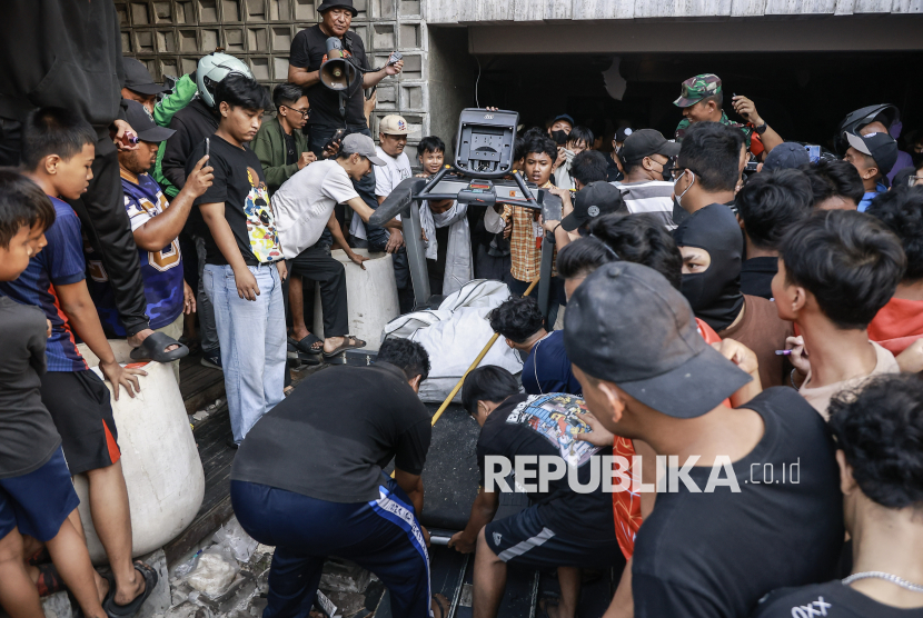 Massa mengeluarkan barang milik anggota DPR Ahmad Sahroni dari dalam rumahnya di kawasan Tanjung Priok, Jakarta, Sabtu (30/8/2025). 