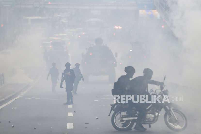 Aparat polisi menggunakan gas air mata untuk membubarkan pengunjuk rasa selama demonstrasi di luar gedung parlemen di Jakarta, Indonesia, 11 April 2022. 