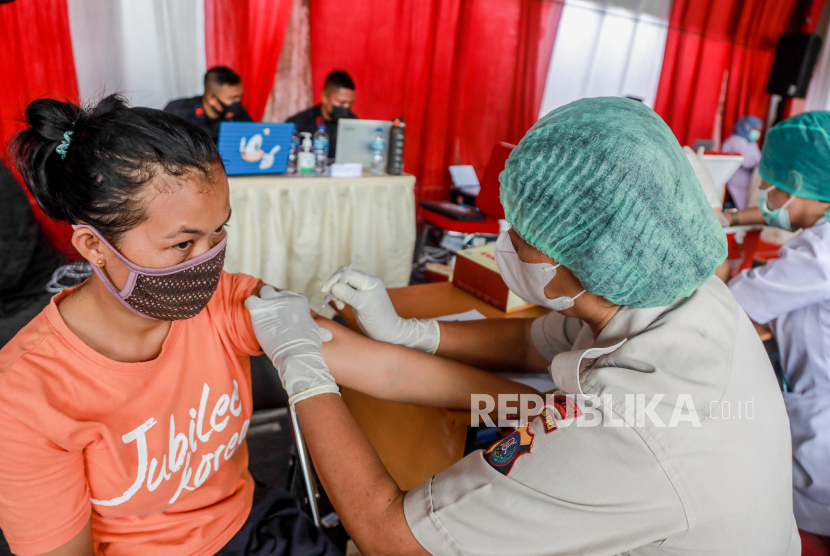 Seorang petugas kesehatan menyuntikkan satu dosis vaksin Sinovac COVID-19 selama kampanye vaksinasi untuk pedagang di pasar tradisional di Medan, Indonesia, 17 September 2021. Vaksinasi dinilai menjadi salah satu upaya memperkuat perekonomian. 