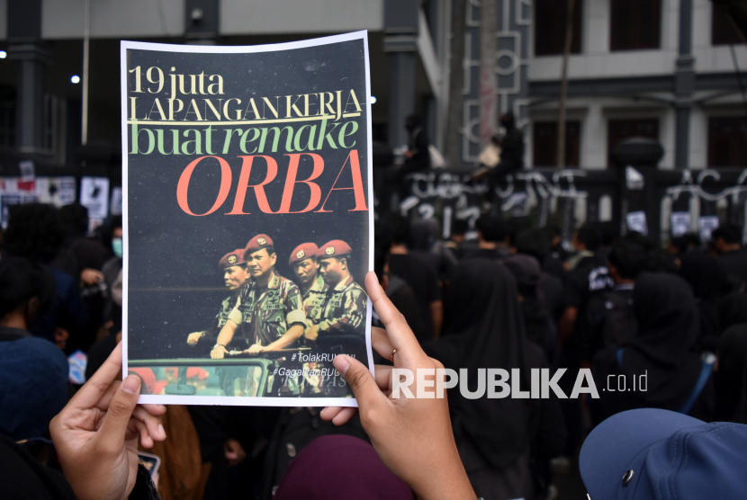 Pengunjuk rasa memegang poster tuntutan saat menggelar aksi di depan Gedung DPRD Kota Malang, Jawa Timur, Ahad (23/3/2025). Unjuk rasa gabungan dari berbagai elemen mahasiswa tersebut berakhir ricuh. Massa membakar sejumlah bangunan di Gedung DPRD Kota Malang.