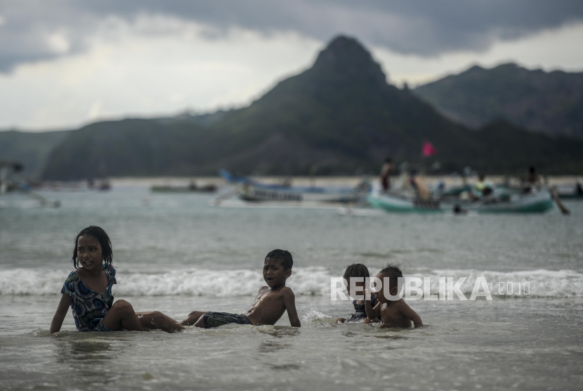 Anak-anak saat main air di tepi Pantai Selong Belanak, Lombok Tengah, Nusa Tenggara Barat. Instruktur renang menilai baju renang warna biru bisa membahayakan keselamatan anak dalam kondisi darurat.