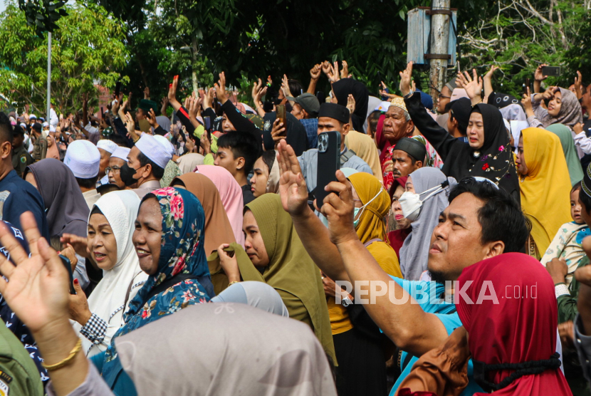 Sejumlah kerabat melambaikan tangan kepada jamaah calon haji di halaman aula GPU Palampang Tarung, Palangka Raya, Kalimantan Tengah, Ahad (4/6/2023).