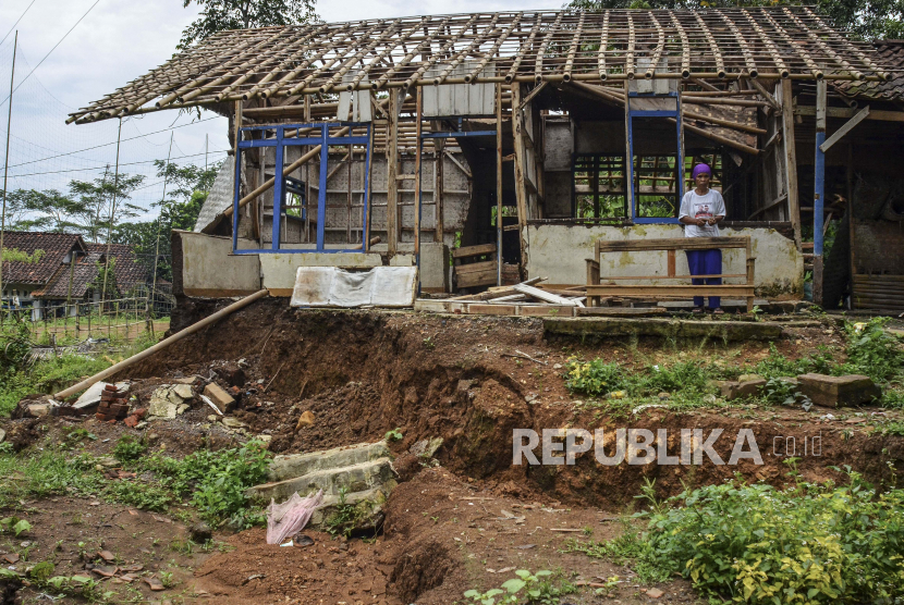Seorang warga menunjukan rumah yang rusak dan dikosongkan penghuninya akibat pergerakan tanah di Kampung Cigorowong, Setiawargi, Kecamatan Tamansari, Kota Tasikmalaya, Jawa Barat, Selasa (23/2/2021). Sedikitnya lima rumah warga rusak akibat pergerakan tanah dan mengancam 20 rumah lainnya. 
