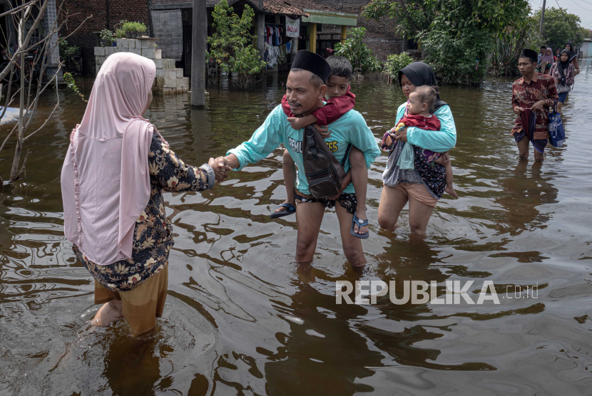Warga bersilaturahmi dengan tetangganya saat perayaan Lebaran di tengah banjir yang melanda Desa Sayung, Kecamatan Sayung, Kabupaten Demak, Jawa Tengah, Rabu (10/4/2024). 