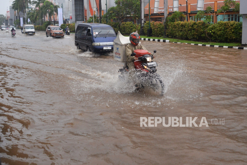 Kendaraan menerobos genangan air yang merendam di Jalan Boulevard Raya, Kelapa Gading, Jumat (22/3/2024). DKI tengah berinovasi sistem pengendali banjir.