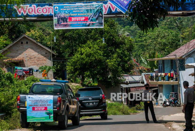 Sejumlah petugas kepolisian berjaga di depan pintu masuk wisata ke Baduy di Desa Ciboleger, Lebak, Banten, Sabtu (30/5/2020). Pemda setempat menutup wisata budaya Baduy dalam rangka antisipasi pencegahan penyebaran COVID-19 hingga waktu yang belum ditentukan