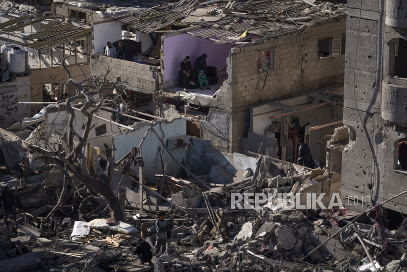 Warga Palestina menyaksikan kehancuran akibat serangan Israel di Jalur Gaza di Rafah pada Senin, 12 Februari 2024.