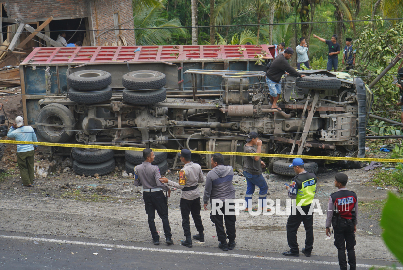 Polisi berjaga di lokasi kecelakaan truk tronton bermuatan pasir tabrak mobil angkutan umum di jalan turunan Magelang-Purworejo Desa Kalijambe, Bener, Purworejo, Jawa Tengah, Rabu (7/5/2025). Kecelakaan maut yang diduga akibat rem truk tronton tidak berfungsi tersebut menyebabkan 11 orang meninggal dunia dan 6 orang luka-luka. 