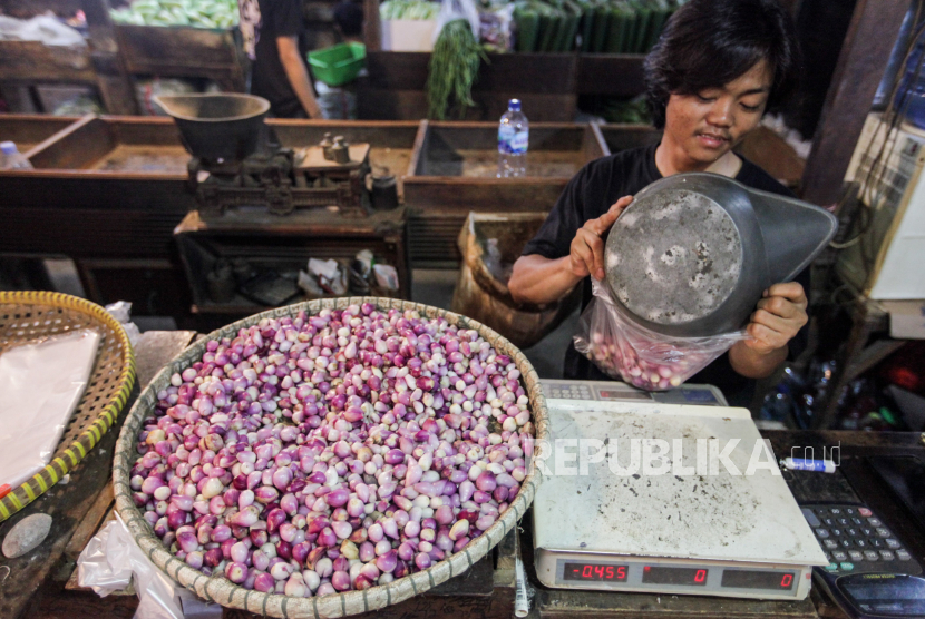 Pedagang memasukan bawang merah ke plastik belanjaan di Pasar Senen, Jakarta, Jumat (19/4/2024). 