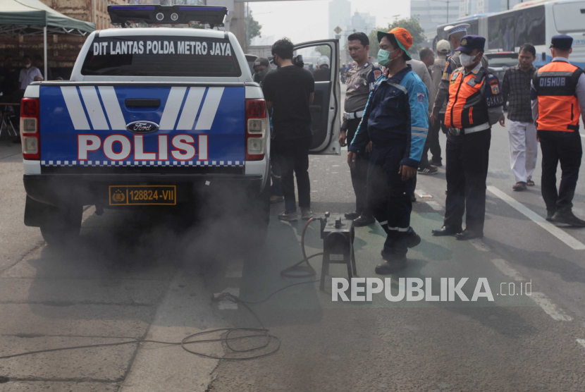 Petugas melakukan uji emisi terhadap kendaraan mobil polisi di Subdit Gakkum Ditlantas Polda Metro Jaya, Jakarta, Jumat (1/9/2023). 