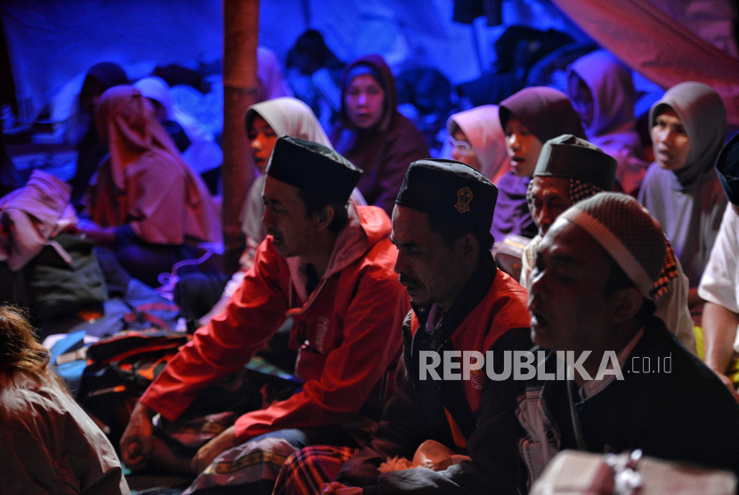 Pengungsi berdoa di dalam tenda darurat di Cianjur, ilustrasi