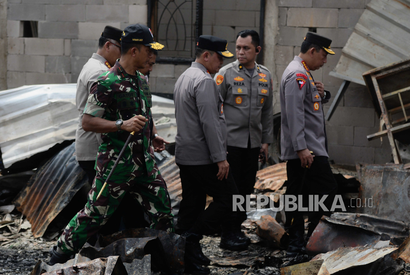Kapolri Jenderal Pol Listyo Sigit Prabowo (kanan) bersama Kapolda Metro Jaya Irjen Pol Fadil Imran (ketiga kanan) saat meninjau lokasi kebakaran depo Pertamina Plumpang di kawasan Rawa Badak, Jakarta, Sabtu (4/3/2023).