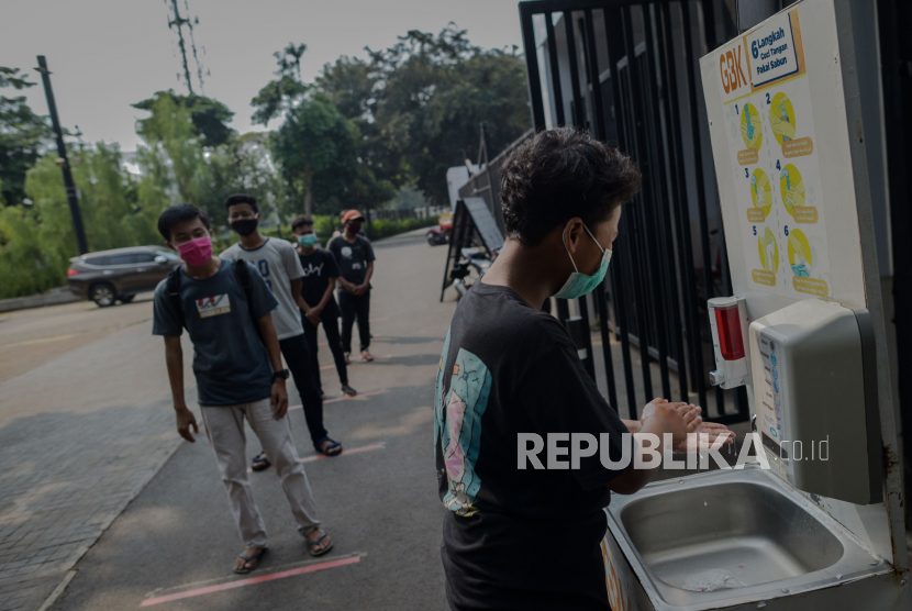 Pengunjung menerapkan jarak fisik saat mengantre untuk cuci tangan di kawasan Gelora Bung Karno,  Jakarta.