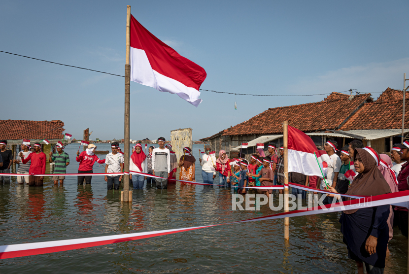Sejumlah warga mengikuti upacara bendera di perkampungan mereka yang terendam banjir rob (limpasan air laut ke daratan) di Dukuh Timbulsloko, Sayung, Demak, Jawa Tengah, Rabu (17/8/2022).(Ilustrasi)