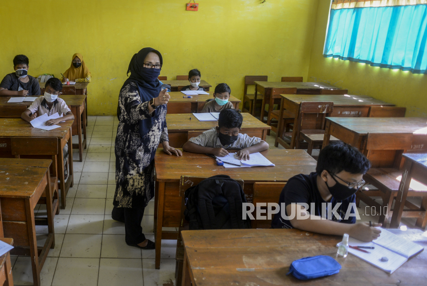 Seorang guru memberikan penjelasan kepada anak-anak saat uji coba pembelajaran tatap muka (ilustrasi)