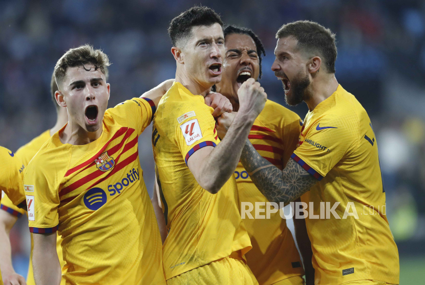 Striker FC Barcelona Robert Lewandowski (tengah) melakukan selebrasi usai mencetak gol 1-2 dari titik penalti pada pertandingan sepak bola LaLiga Spanyol antara RC Celta Vigo dan FC Barcelona, di Vigo, Spanyol, Ahad (18/2/2024) dini hari WIB.