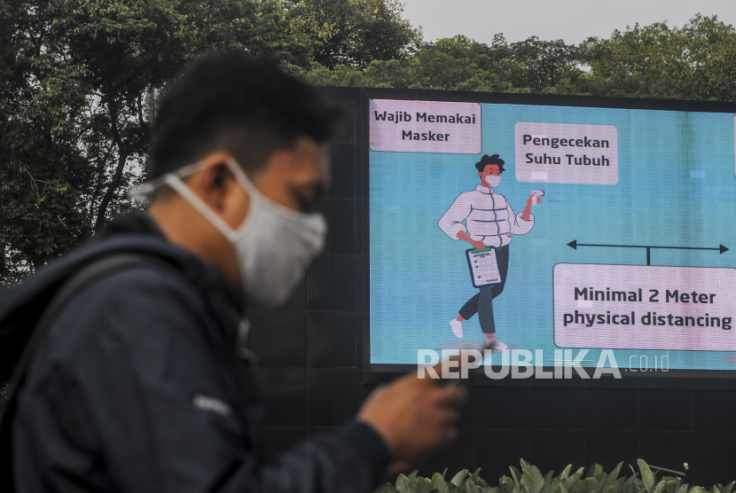 Seorang warga menggunakan masker saat berjalan di kawasan Sudirman, Jakarta, Rabu (14/10). Gubernur DKI Jakarta Anies Baswedan mengatakan penggunaan masker oleh masyarakat Jakarta baru mencapai 70 persen dan harus ditingkatkan kembali menjadi 85 persen untuk mengendalikan penyebaran Covid-19. Republika/Putra M. Akbar