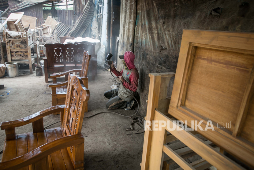 Pekerja menyelesaikan proses pembuatan kerajinan mebel di Pasar Mebel Gilingan, Solo, Jawa Tengah, Kamis (6/1/2022).