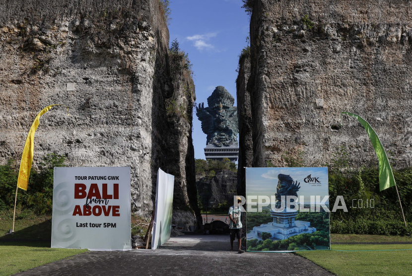 Seorang pekerja berjalan saat monumen raksasa Garuda Wisnu Kencana (GWK) berdiri di latar belakang di sebuah tempat yang sedang dibangun di taman budaya GWK, salah satu tempat utama untuk KTT Pemimpin G20 mendatang di Bali, Indonesia, 25 Mei 2022. 