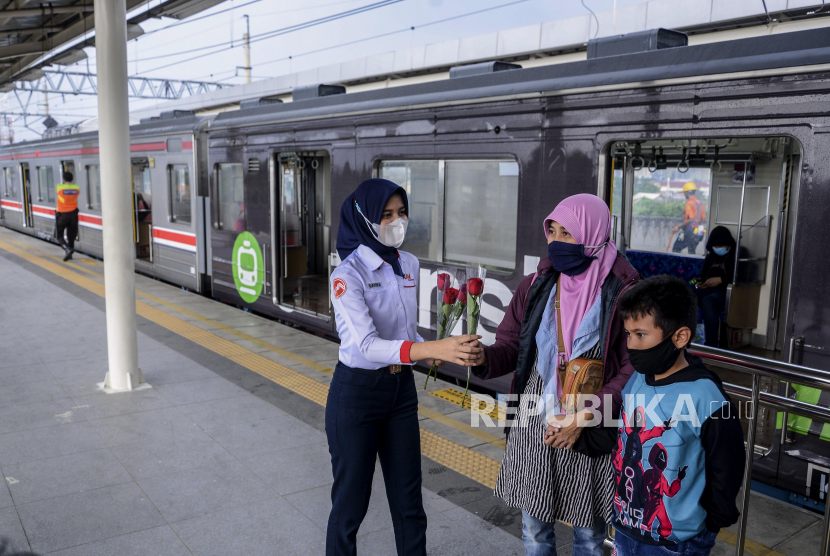 Petugas KAI Commuter Line membagikan bunga mawar kepada penumpang saat anti pelecehan seksual di Stasiun Manggarai, Jakarta Selatan, Kamis (22/12/2022).