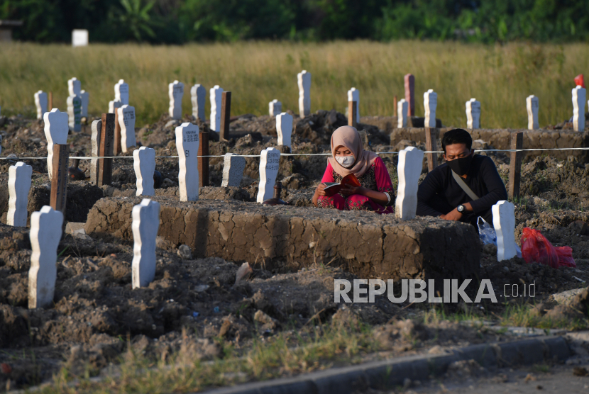 Peziarah berdoa di pemakaman khusus kasus Covid-19 di Tempat Pemakaman Umum (TPU) Keputih, Surabaya, Jawa Timur, Sabtu (16/5).