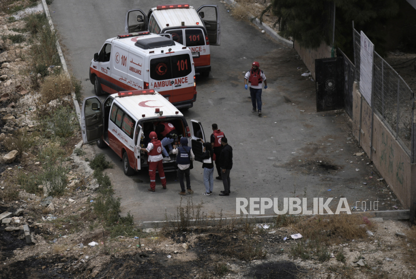 Paramedis Bulan Sabit Merah Palestina mengevakuasi seorang jurnalis yang terluka ketika dia ditembak saat meliput pertempuran antara pasukan Israel dan warga Palestina di kota Jenin, Tepi Barat, Senin, (19/6/2023).