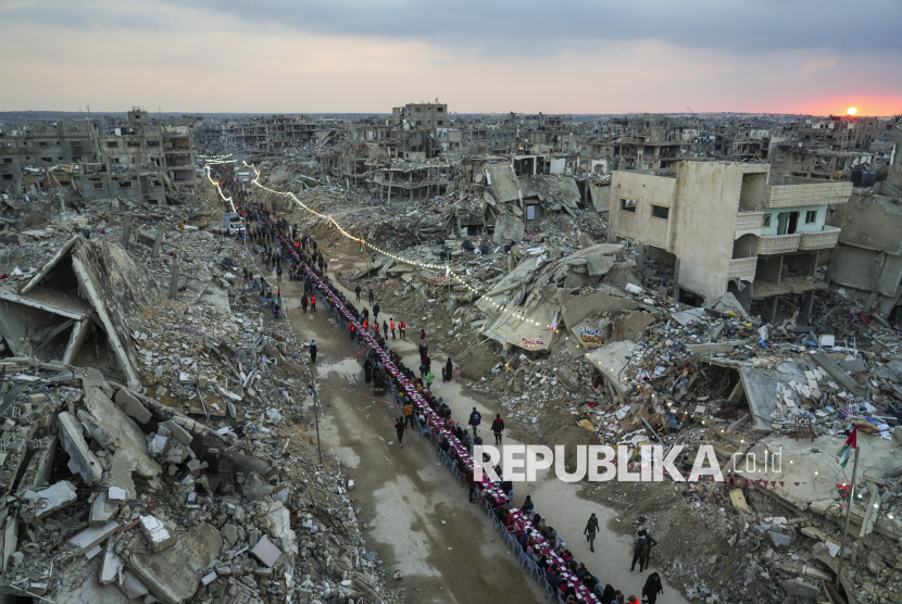 Warga Palestina berbuka puasa bersama diantara reruntuhan rumah dan bangunan di Rafah, Jalur Gaza selatan, Sabtu (1/3/2025). Pasca gencatan senjata, warga Palestina menjalani bulan suci Ramadhan dengan lebih baik jika dibandingkan tahun sebelumnya. Meski hidup ditengah kondisi kota yang hancur, namun pada Ramadhan tahun ini warga Palestina di Gaza bisa melakukan buka puasa dan ibadah Ramadhan bersama dengan tenang. 