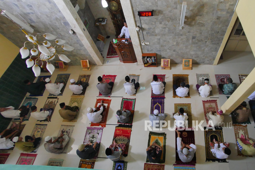 Jamaah melaksanakan shalat Jumat dengan menerapkan kaidah penjarakkan sosial (Social Distancing) pada pengaturan shafnya.