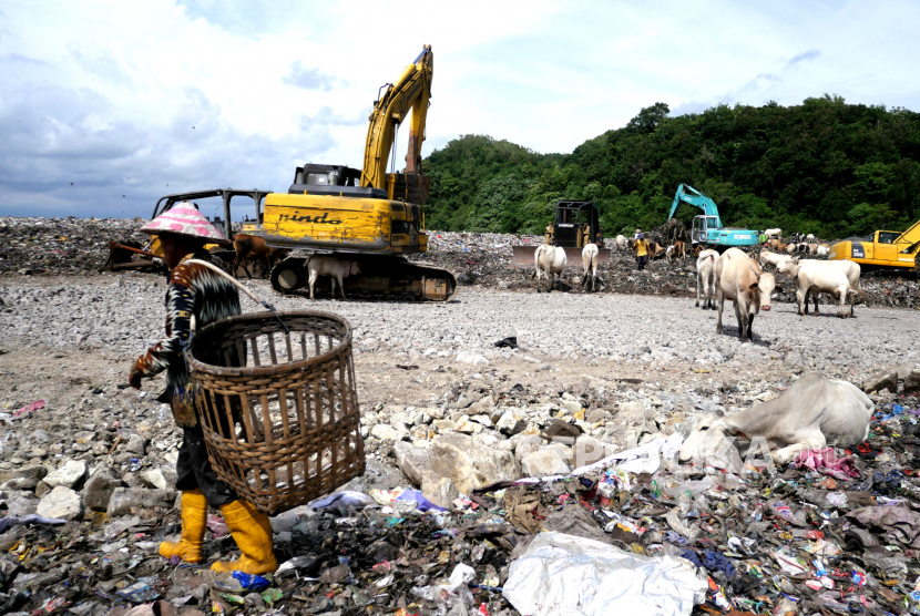 Eksavator mengurai gundukan sampah  di TPST Piyungan, Bantul, Yogyakarta, Selasa (22/12). Sejak Jumat (18/12) jalan akses menuju pembuangan sampah TPST Piyungan diblokir oleh warga sekitar.