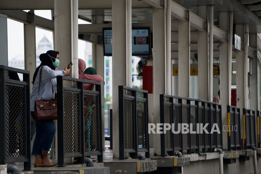 Sejumlah penumpang menanti bus TransJakarta di halte Bundaran Hotel Indonesia,Jakarta, Kamis (30/12). Pemprov DKI mengingatkan warga untuk mewaspadai penularan Covid-19, termasuk akibat infeksi SARS-CoV-2 varian omicron yang kini mayoritas berasal dari transmisi lokal. 